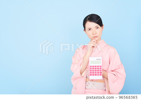 一個穿著和服的女人拿著計算器 一個穿著和服的女人拿著計算器 96568365