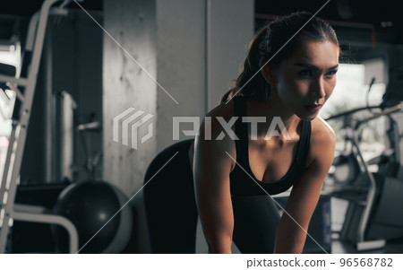 Close-up young woman lifts single kettlebell in the gym. 96568782