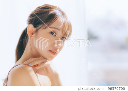 Photo of a young woman doing skin care in the morning sun Photo of a young woman doing skin care in the morning sun 96570700