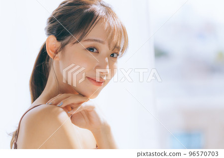 Photo of a young woman doing skin care in the morning sun 96570703