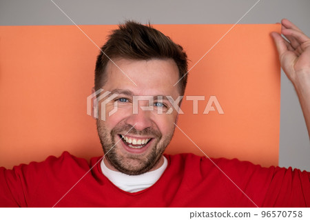 Yyoung man smiling while standing isolated on orange background Yyoung man smiling while standing isolated on orange background 96570758