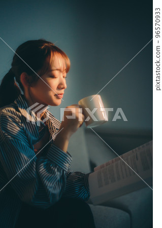 一位年輕女子在夕陽下讀書的照片 96570933