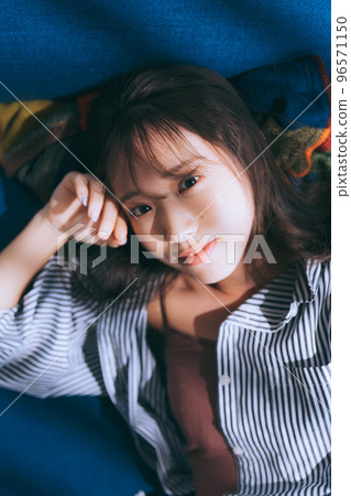 Photo of a young woman lying on a sofa 96571150