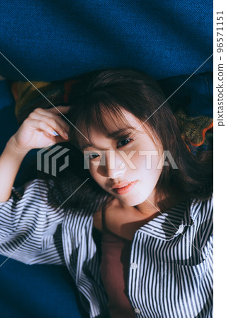 Photo of a young woman lying on a sofa 96571151