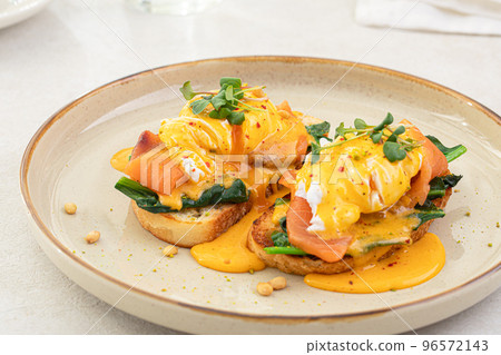 Portion of eggs benedict toast with salmon Portion of eggs benedict toast with salmon 96572143