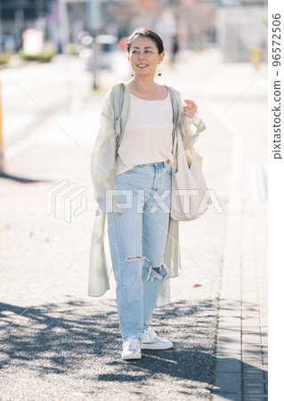 Middle-aged woman walking in the city 96572506