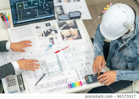 Construction supervisor directing cost reduction First-class architect meeting construction site 96573017