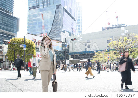 Business woman making a phone call with a smartphone Shibuya Scramble Crossing 96573387