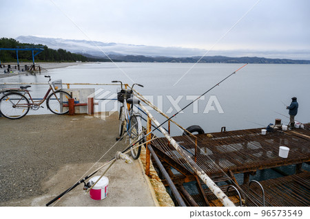 Old pier with bicycles and fishing gear at Cape Pitsunda on Black Sea coast in Abkhazia in winter 96573549
