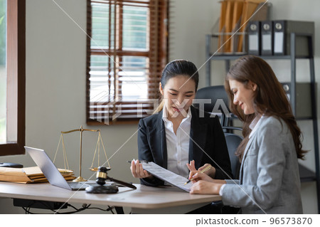 Female lawyer discuss to a legal document explaining the terms of a consultation with a businesswoman. before signing a contract with a law firm. Female lawyer discuss to a legal document explaining the terms of a consultation with a businesswoman. before signing a contract with a law firm. 96573870