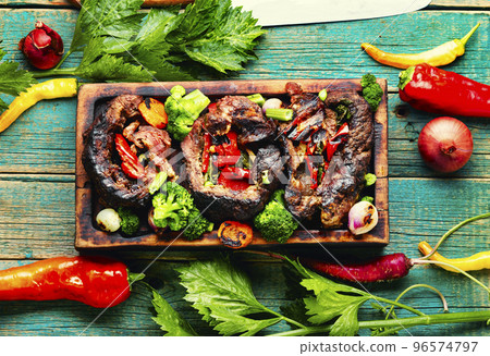 Grilled meat with vegetables on cutting board Grilled meat with vegetables on cutting board 96574797