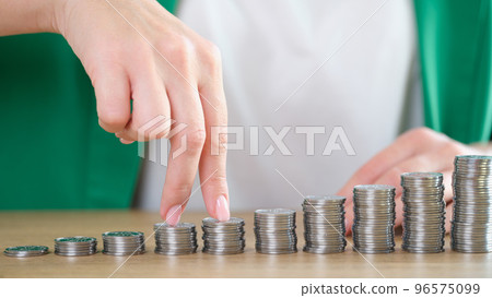 Woman fingers going up on bar chart collected of silver coins 96575099