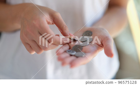 Female hands holding and counting silver coins 96575128