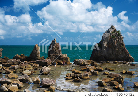 Tourists walking around Hashigui-iwa rocks at low tide under the autumn sky Tourists walking around Hashigui-iwa rocks at low tide under the autumn sky 96576422