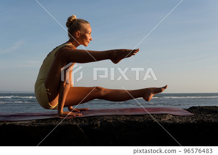 beautiful woman doing yoga on the beach. beautiful woman doing yoga on the beach. 96576483