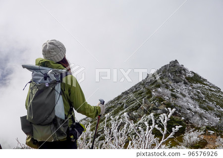 Climbing a snowy mountain 96576926