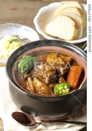 Piping hot beef stew with lots of ingredients such as broccoli, carrots and shimeji mushrooms in a pot, salad and bread Piping hot beef stew with lots of ingredients such as broccoli, carrots and shimeji mushrooms in a pot, salad and bread 96577404