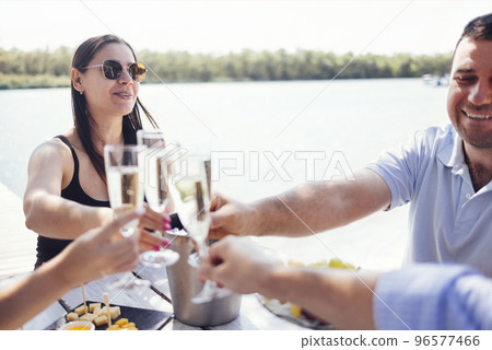 Happy people on the beach having a party, drinking and having a lot of fun in the sunse 96577466