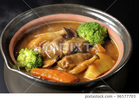 在黑色背景的鍋裡燉熱牛肉，裡面有西蘭花、胡蘿蔔和 shimeji 蘑菇等多種配料 96577703