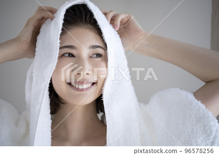 Young woman wiping her hair with a towel 96578256