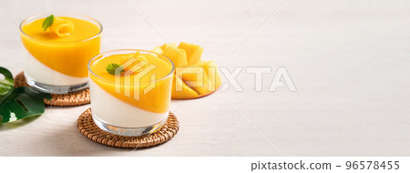 Delicious double colored mango panna cotta mousse pudding on wooden table background. 96578455
