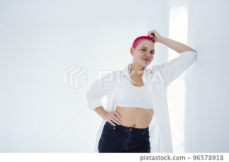 Beautiful relaxed woman in light clothes and red shot hair Beautiful relaxed woman in light clothes and red shot hair 96578918