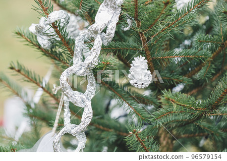 Aluminium foil and painted pine cone handmade decoration on Christmas tree outdoor. Diy creative ideas for children. Environment, recycle, upcycling and zero waste concept. Selective focus, copy space Aluminium foil and painted pine cone handmade decoration on Christmas tree outdoor. Diy creative ideas for children. Environment, recycle, upcycling and zero waste concept. Selective focus, copy space 96579154