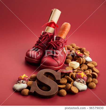 Saint Nicholas - Sinterklaas day with shoe, carrot and traditional sweets on red background Saint Nicholas - Sinterklaas day with shoe, carrot and traditional sweets on red background 96579830