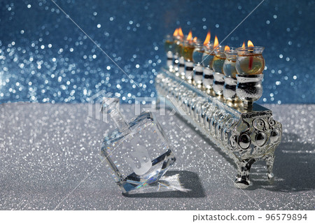 Jewish holiday Hanukkah background with oil menorah and dreidel with letters Gimel and Nun. 96579894