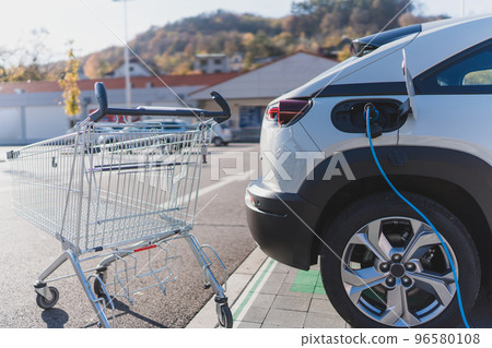Modern electric car charging at supermarket parking. 96580108