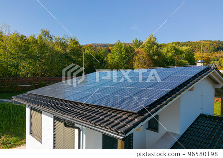 High angle view of solar photovoltaic panels on roof, alternative energy, saving resources and sustainable lifestyle concept. High angle view of solar photovoltaic panels on roof, alternative energy, saving resources and sustainable lifestyle concept. 96580198