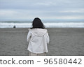 woman standing by the sea in winter 96580442