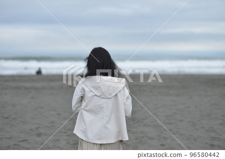 woman standing by the sea in winter 96580442