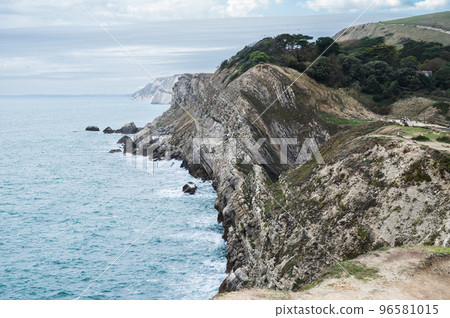 Beautiful view of Stair Hole, small cove to the west of Lulworth Cove in Dorset, Untited Kingdom. View of rock formations and nature made caves and blue sea, selective focus Beautiful view of Stair Hole, small cove to the west of Lulworth Cove in Dorset, Untited Kingdom. View of rock formations and nature made caves and blue sea, selective focus 96581015