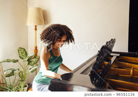 Young black lady playing a piano Young black lady playing a piano 96581116