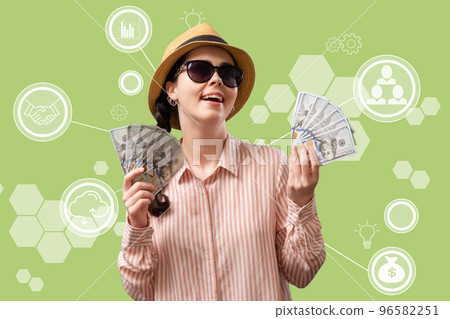 Investment. A rich happy joyful woman in glasses and a straw hat holds fans of American dollars. Green background with digital service. Concept of money remittance and cryptocurrency Investment. A rich happy joyful woman in glasses and a straw hat holds fans of American dollars. Green background with digital service. Concept of money remittance and cryptocurrency 96582251