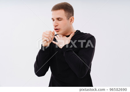 a man in black clothes coughs on a white background.  96582690