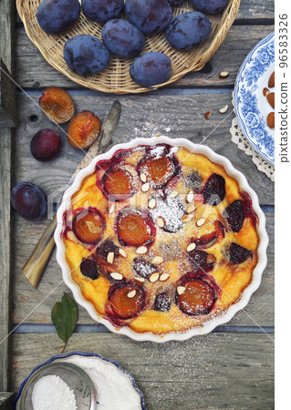 Damson blue plum clafoutis (flan), icing sugar and almonds dressing, french cuisine 96583326