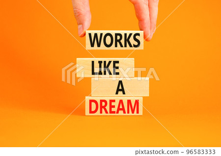 Works like a dream symbol. Concept words Works like a dream on wooden cubes. Beautiful orange table orange background. Businessman hand. Business motivational works like a dream concept. Copy space. 96583333