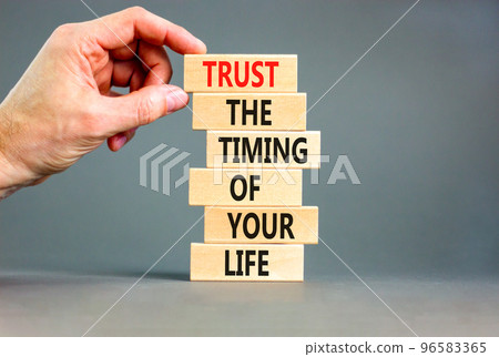 Timing of your life symbol. Concept words Trust the timing of your life on wooden blocks on a beautiful grey table grey background. Businessman hand. Business trust the timing of your life concept Timing of your life symbol. Concept words Trust the timing of your life on wooden blocks on a beautiful grey table grey background. Businessman hand. Business trust the timing of your life concept 96583365