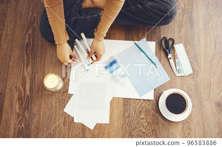 Young brunette african american woman creating her Feng Shui wish map using scissors Young brunette african american woman creating her Feng Shui wish map using scissors 96583886