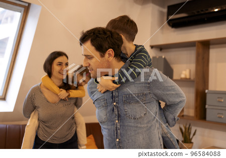 Happy parents with son and daughter posing indoors 96584088