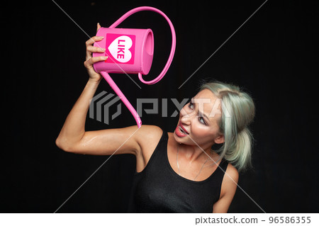 Woman with pink watering can isolated on black. Running out of likes, no likes, dislike concept 96586355