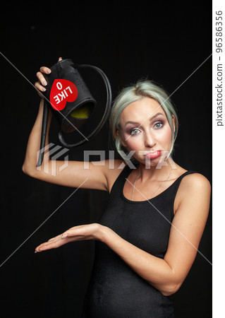 Upset woman with black watering can. Running out of likes, no likes, dislike concept Upset woman with black watering can. Running out of likes, no likes, dislike concept 96586356