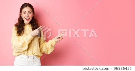 Portrait of excited smiling woman giving information, showing way, pointing fingers right at copyspace aside, standing upbeat against pink background Portrait of excited smiling woman giving information, showing way, pointing fingers right at copyspace aside, standing upbeat against pink background 96586435