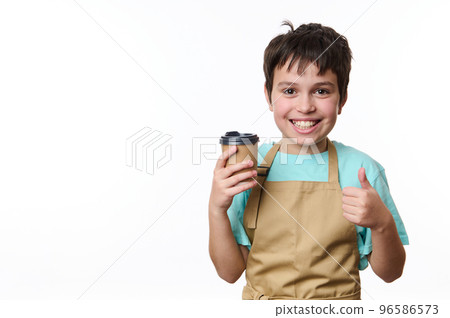 Happy Caucasian teenage boy, bartender barista holding, selling a takeaway hot coffee drink in a paper cup, showing thumb up, isolated over white background with copy space for your promotional text Happy Caucasian teenage boy, bartender barista holding, selling a takeaway hot coffee drink in a paper cup, showing thumb up, isolated over white background with copy space for your promotional text 96586573