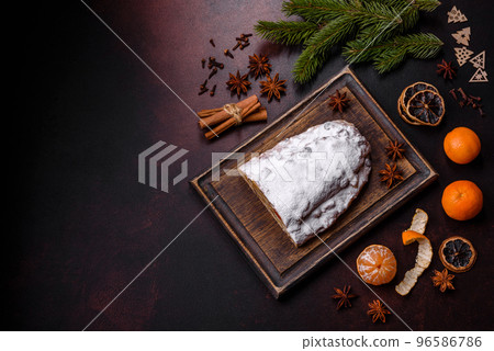 Christmas pie stollen with marzipan, berries and nuts on a dark concrete background 96586786