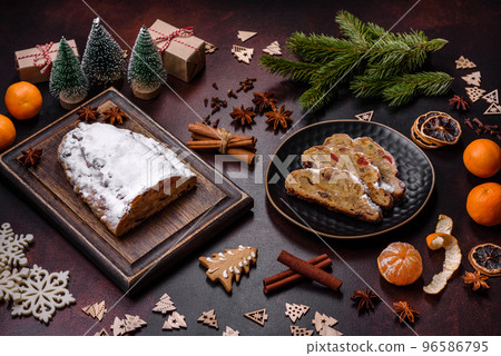 Christmas pie stollen with marzipan, berries and nuts on a dark concrete background 96586795