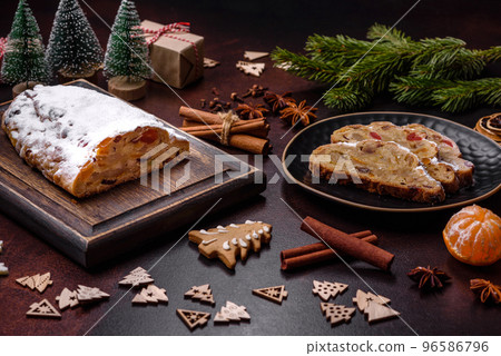 Christmas pie stollen with marzipan, berries and nuts on a dark concrete background 96586796