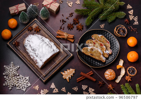 Christmas pie stollen with marzipan, berries and nuts on a dark concrete background 96586797